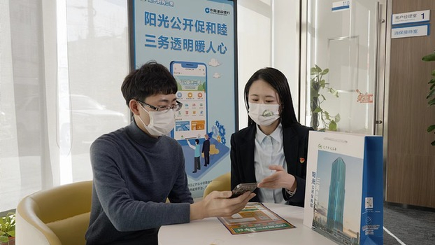 　　建行客户经理为客户介绍辽宁阳光三务平台惠民补贴政策信息。受访者供图
