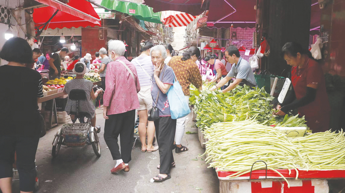     菜市中买菜的市民熙熙攘攘，很热闹