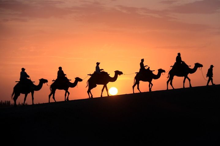 6月24日清晨，游客在甘肃省敦煌市鸣沙山月牙泉景区游览。新华社发（张晓亮 摄）