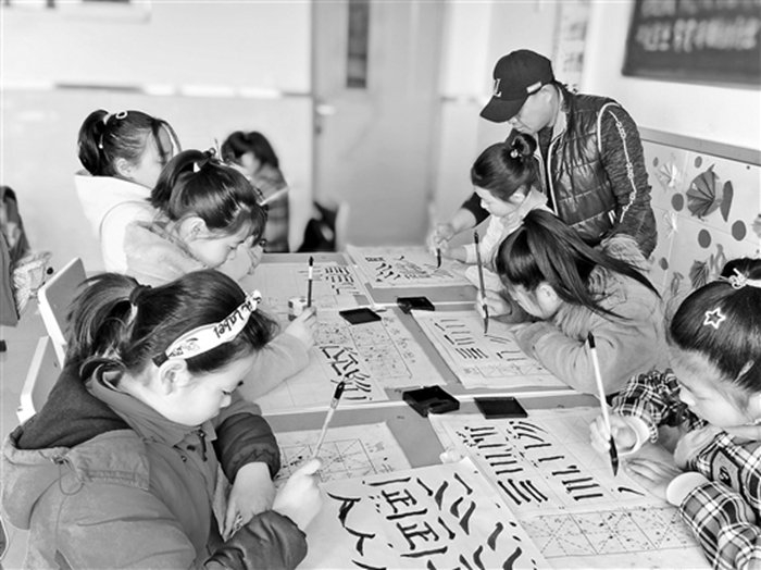 2019年，民主小学的学生在上书法课。