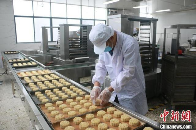 图为工人在摆放螺蛳粉月饼。林馨 摄