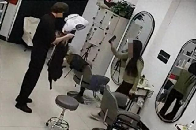 涉事女子用手机向理发店店主“亮证”。视频截图