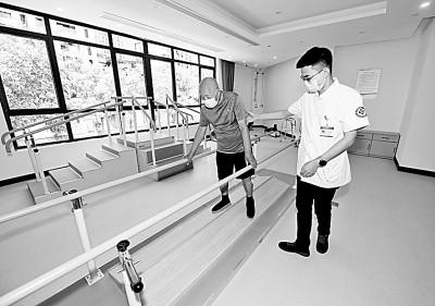     浙江省诸暨市东盛社区卫生服务站的医生在给一名患者进行康复训练。新华社发