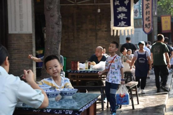 清晨在小吃街上的游客。 原韬雄摄