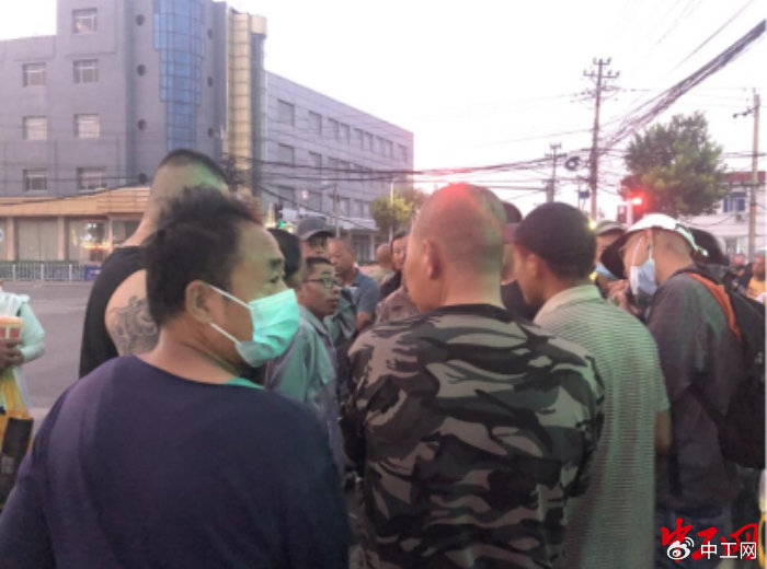 工人围着工头询问招工情况。中工网记者 朱洁英 摄
