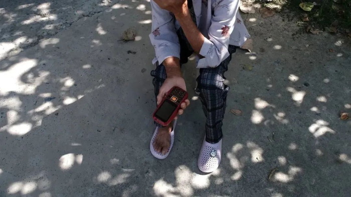 奶奶拿出她的老人机给我看。狮子坐/摄