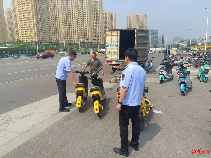 ▲执法人员清理街面上的松果共享电单车 