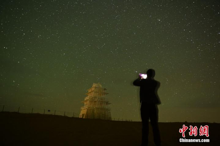 　　9月14日凌晨，甘肃省武威市民勤县苏武沙漠大景区腹地摘星小镇内，游人拍摄景区内的“摘星”景点。中新社记者 李亚龙 摄