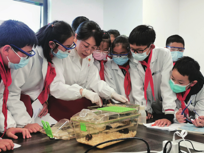 马瑜婷（中）给少年儿童进行科普