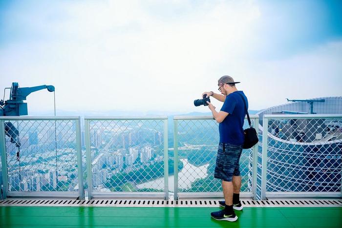 美国摄影师Eric Garrison站在星河双子塔西塔塔顶俯瞰龙岗。