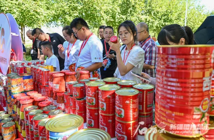 8月25日，嘉宾和游客在首届番茄节活动现场参观番茄加工企业带来的番茄产品。陶维明摄