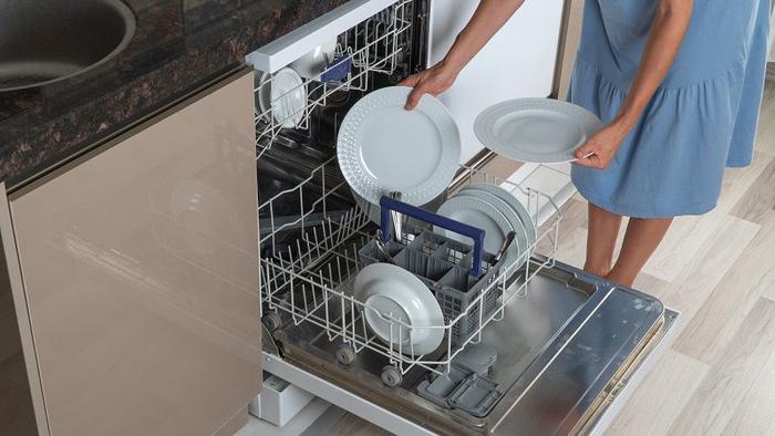 图为消费者正在使用洗碗机做家务。