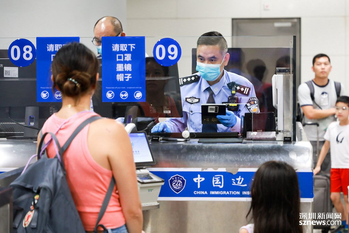 西九龙站边检民警为旅客办理出入境手续。