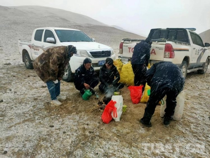 图为先遣乡派出所民警救援途中生火煮茶，在冰天雪地里吃简餐