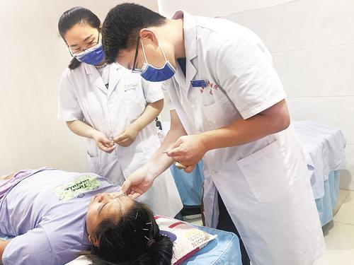    天津市卫生健康委派驻安新县中医医院的第七批成员王文熠（右一）医生为面瘫患者进行针灸。