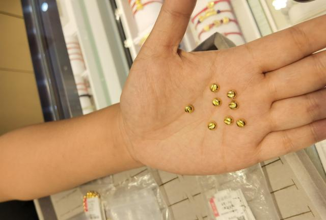 图为一门店销售人员展示金豆产品。新华社记者马晓媛 摄