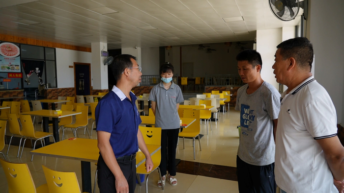 赵长发（左一）和郑静（右一）到长者食堂查看情况，要求及时修复翘起的地板砖。记者 王洪旭 摄