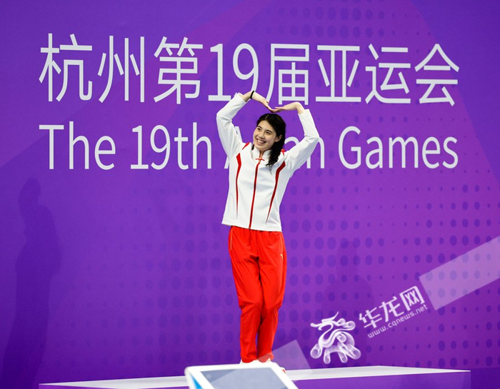 夺得女子200米自由泳金牌的张雨霏向现场观众比心致谢.