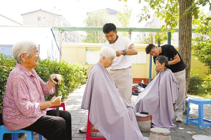 西安市临潼区东大街社区，志愿者在免费给老人理发。 通讯员 王三合摄