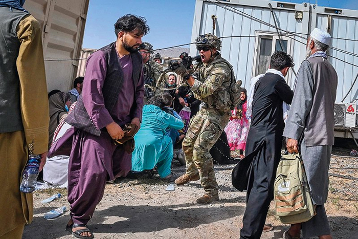 在阿富汗喀布尔机场，一名美军士兵用枪指向一名阿富汗男子（2021 年 8 月 16 日摄）新华社 / 法新