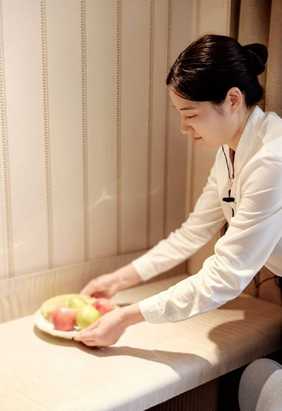 　　图：汉庭员工为住客摆放水果