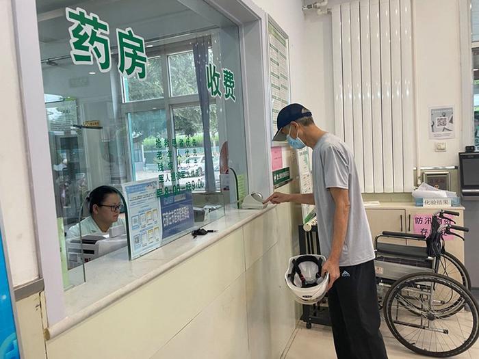 崔炳欣老人正在用医保卡拿药