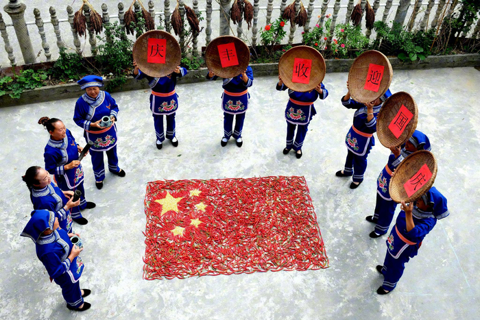 天柱县邦洞街道三团村村民用玉米辣椒摆红旗迎国庆。陈光昌 摄