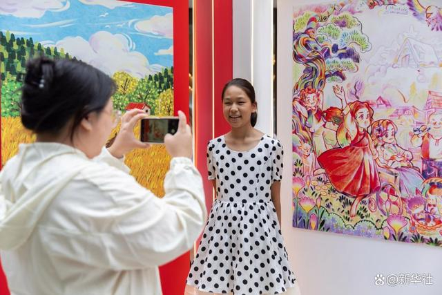 ↑10月2日，人们在上海徐家汇书院广场“一书一画”艺术画展上展出的绘画作品前拍照。新华社记者 王翔 摄