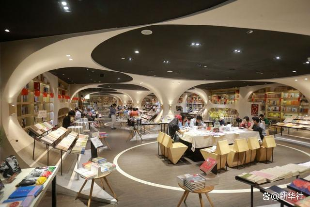 ↑10月2日，在钟书阁扬州珍园店内，读者在阅读书籍。新华社发（孟德龙 摄）
