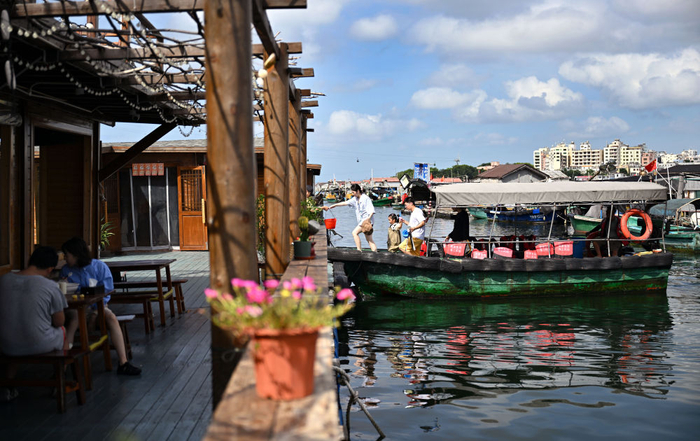 　　10月3日，游客乘坐接驳船抵达疍家渔排海上民宿。新华社记者郭程 摄