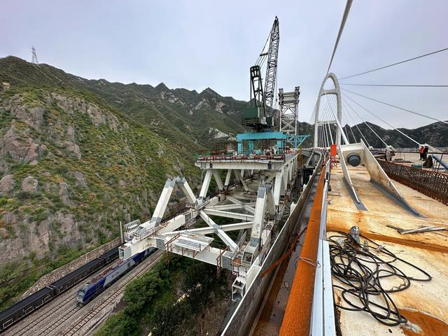 安家庄特大桥紧挨着丰沙铁路线与安家庄站，一列货运列车正从桥下驶过。  新京报记者 裴剑飞 摄