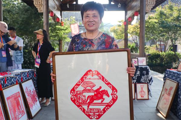 桐庐剪纸传承人申屠美芳展示其创作的杭州亚运会主题作品。 中国网记者 郑伟 摄