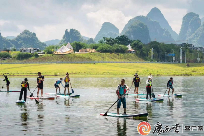 游客在阳朔遇龙湾国际营地玩桨板。