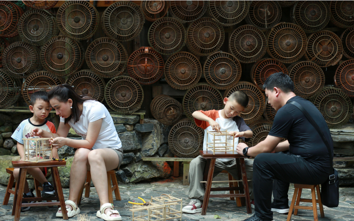 丹寨县龙泉镇卡拉村，小朋友在学习鸟笼编制技艺。肖伟 摄