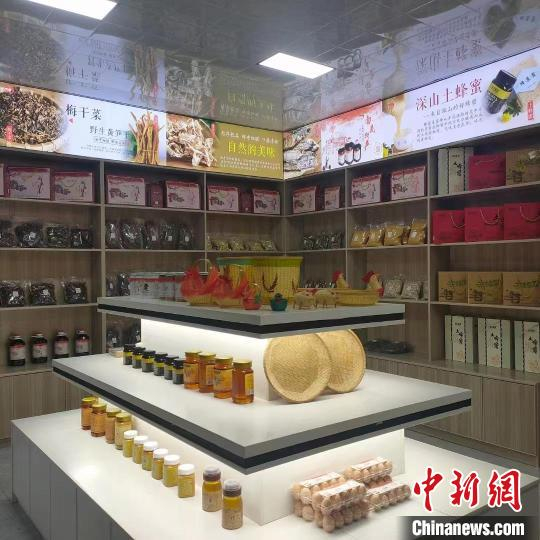 图为江西省瑞昌市南义镇星明村"南义土特产"线下实体店铺内,货架上摆