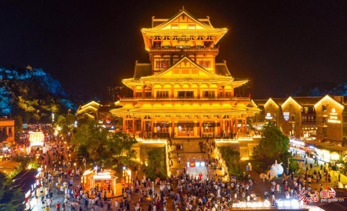 2023年10月4日晚，游客在广西柳州市窑埠古镇龙城阁前游玩。（黎寒池摄/光明图片）