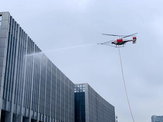 TD550应急救援无人直升机携带水枪、水带演示高楼灭火。受访者供图