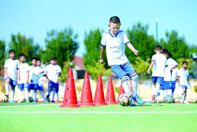 青岛市即墨区龙山中心小学学生在学习足球运动技能。梁孝鹏摄/光明图片