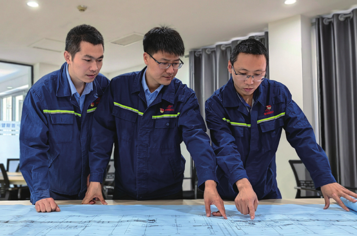 郝晓鹏（中）和同事研究图纸
