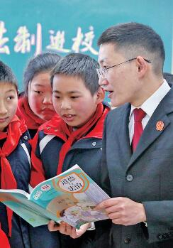 　　江苏海安墩头镇小学教育集团一班级教室内，法官运用相关课本为学生讲解法律知识。周强摄/光明图片