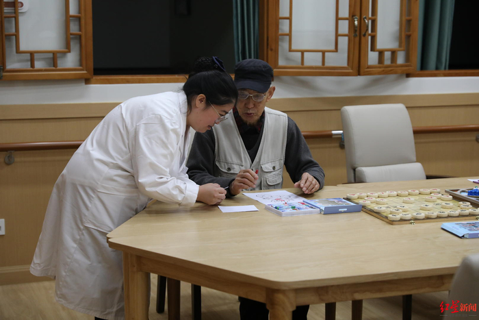 ▲在营门口街道综合为老服务中心，老人正在工作人员指导下画画