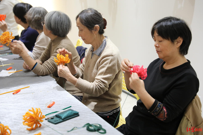 ▲在青羊区有闲生活日间照料中心，老人们正在做手工花