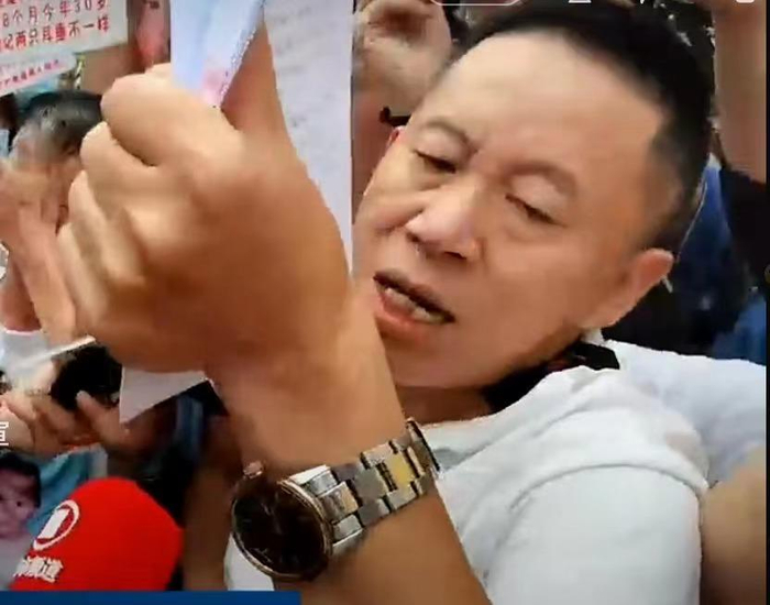 ▲法庭外，孙海洋手举判决书，介绍判决结果