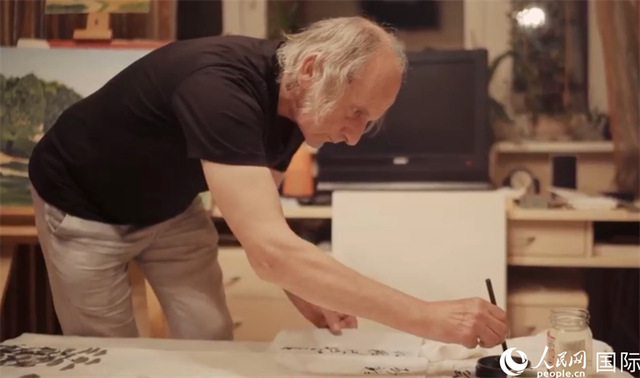 伊戈尔・布尔东诺夫在画作上题词。人民网记者 马天翼摄