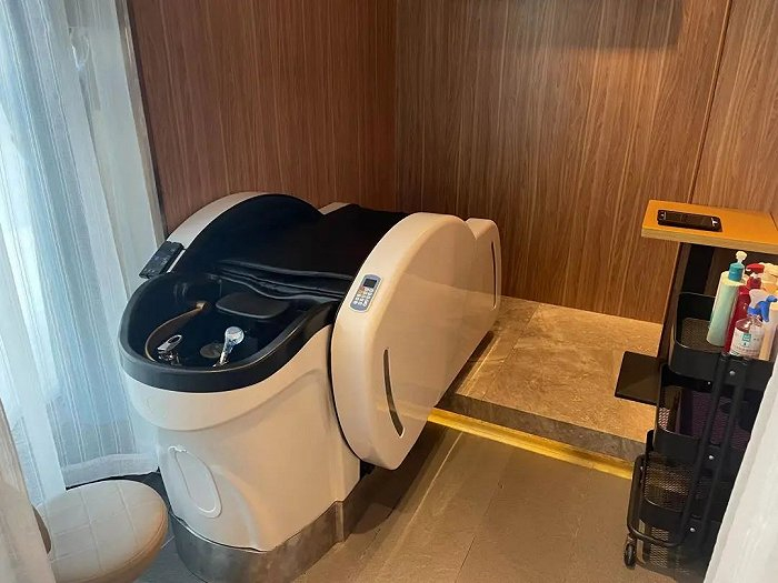 店里新添置的洗头按摩椅，专门放置在门店一角的一片纱帘背后。图 / 每日人物