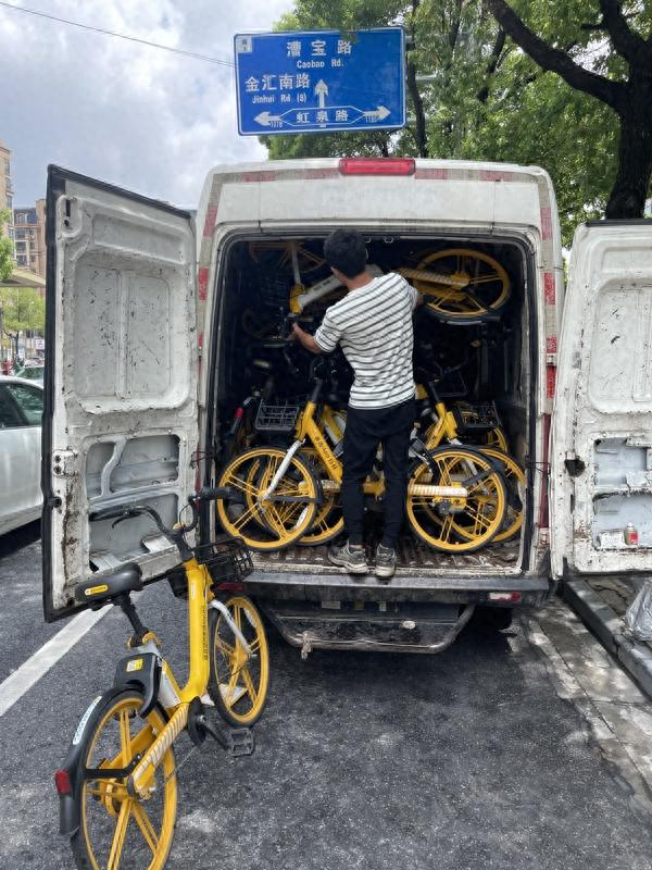 杨青正在搬运单车。朱雅文/摄