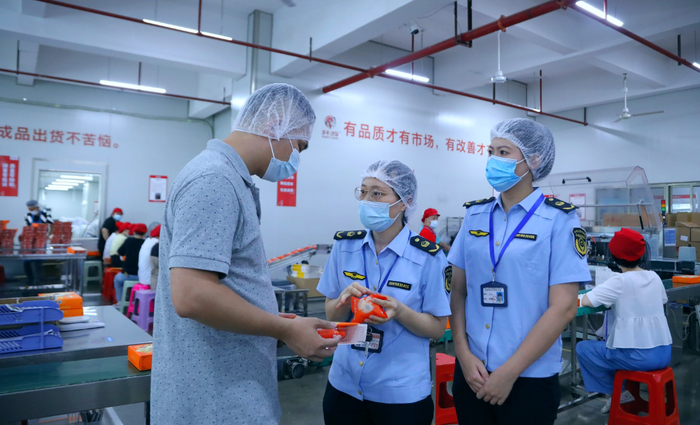 南宁市市场监管局工作人员到广西轩妈食品有限公司帮扶指导。（何正君 摄）