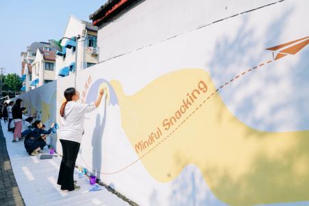 志愿者们用心绘制创意墙面，为美化社区贡献力量