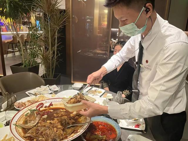 在一家旺顺阁门店，服务人员正在帮客人打包剩余菜品。受访者供图