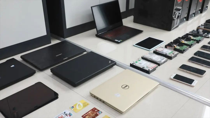 图为民警查扣的犯罪团伙用于作案的手机和电脑。